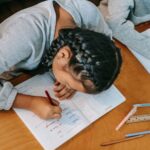 children writing in copybooks at table