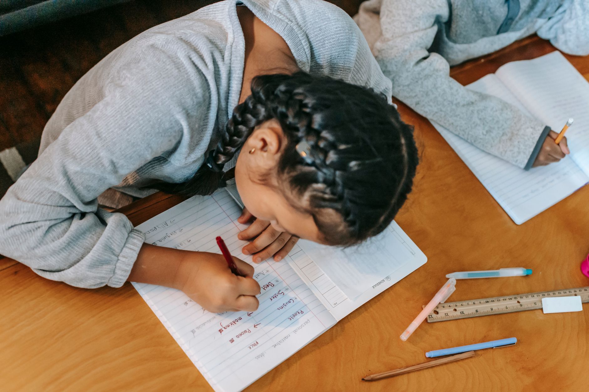 children writing in copybooks at table