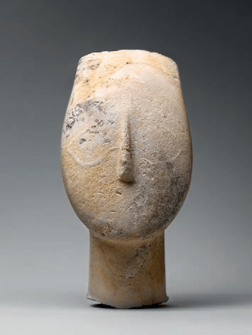 Cabeça de uma figura feminina, escultura anônima em mármore, de cerca de 2700 a 2500 a.C., com face oval e traços simplificados.