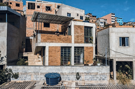Fotografia da Casa do Pomar do Cafezal, com tijolos aparentes, amplas janelas, terraços e cobertura vazada, entre outras construções da comunidade.